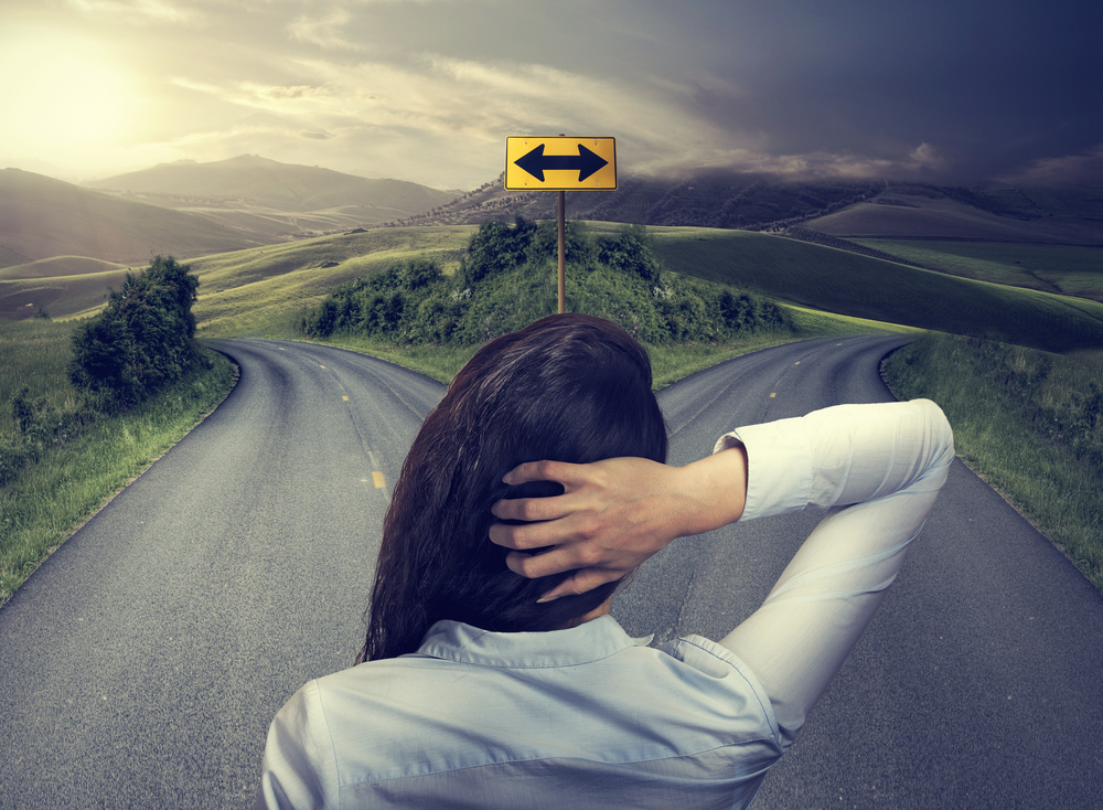 business woman in front of two roads thinking deciding hoping for best taking chance business woman in front of two roads thinking deciding hoping for best taking chance